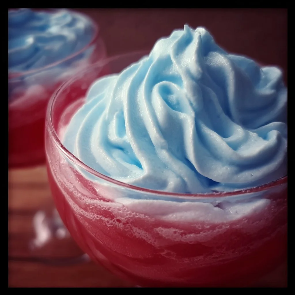 A vibrant bowl of whipped Kool-Aid dessert, garnished and ready to serve.