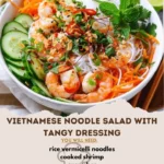 Bowl of Vietnamese Noodle Salad topped with fresh herbs and tangy dressing