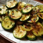 Plate of Italian sautéed zucchini and onions garnished with herbs