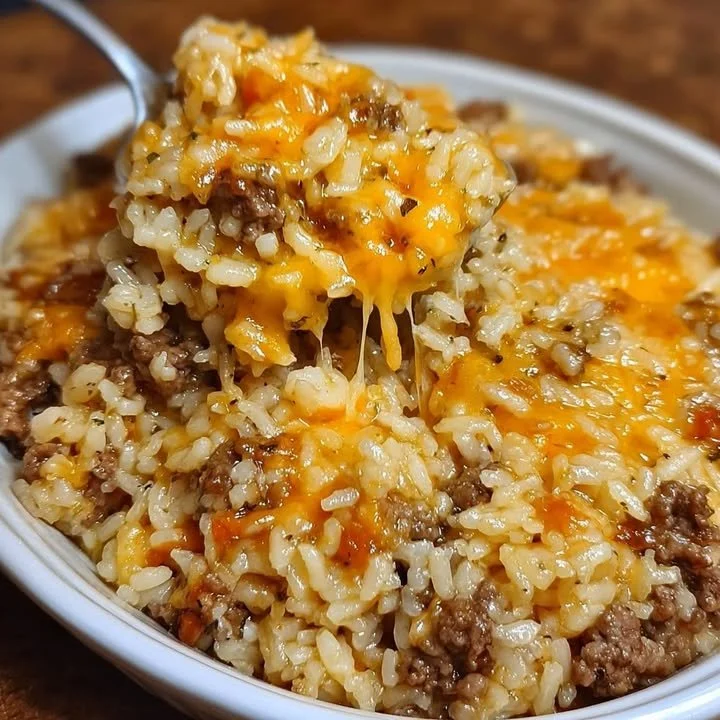 Cheesy ground beef rice casserole with melted cheese and vibrant ingredients.