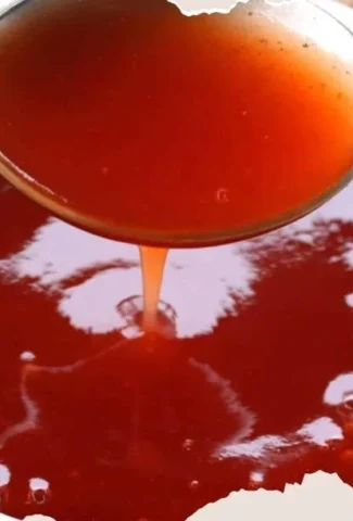 Homemade Chinese Sweet and Sour Sauce served in a bowl on a wooden table.