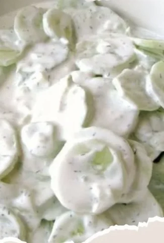 Creamy cucumber salad with herbs and dressing in a bowl