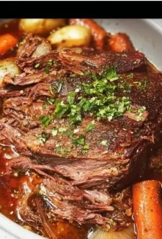 Delicious slow cooker pot roast served with vegetables on a plate.